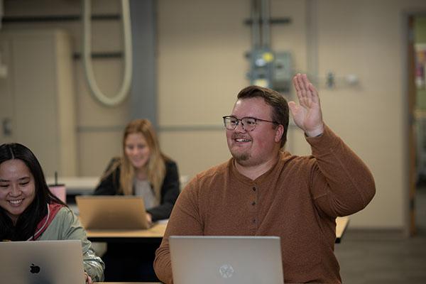 A student raises their hand in class